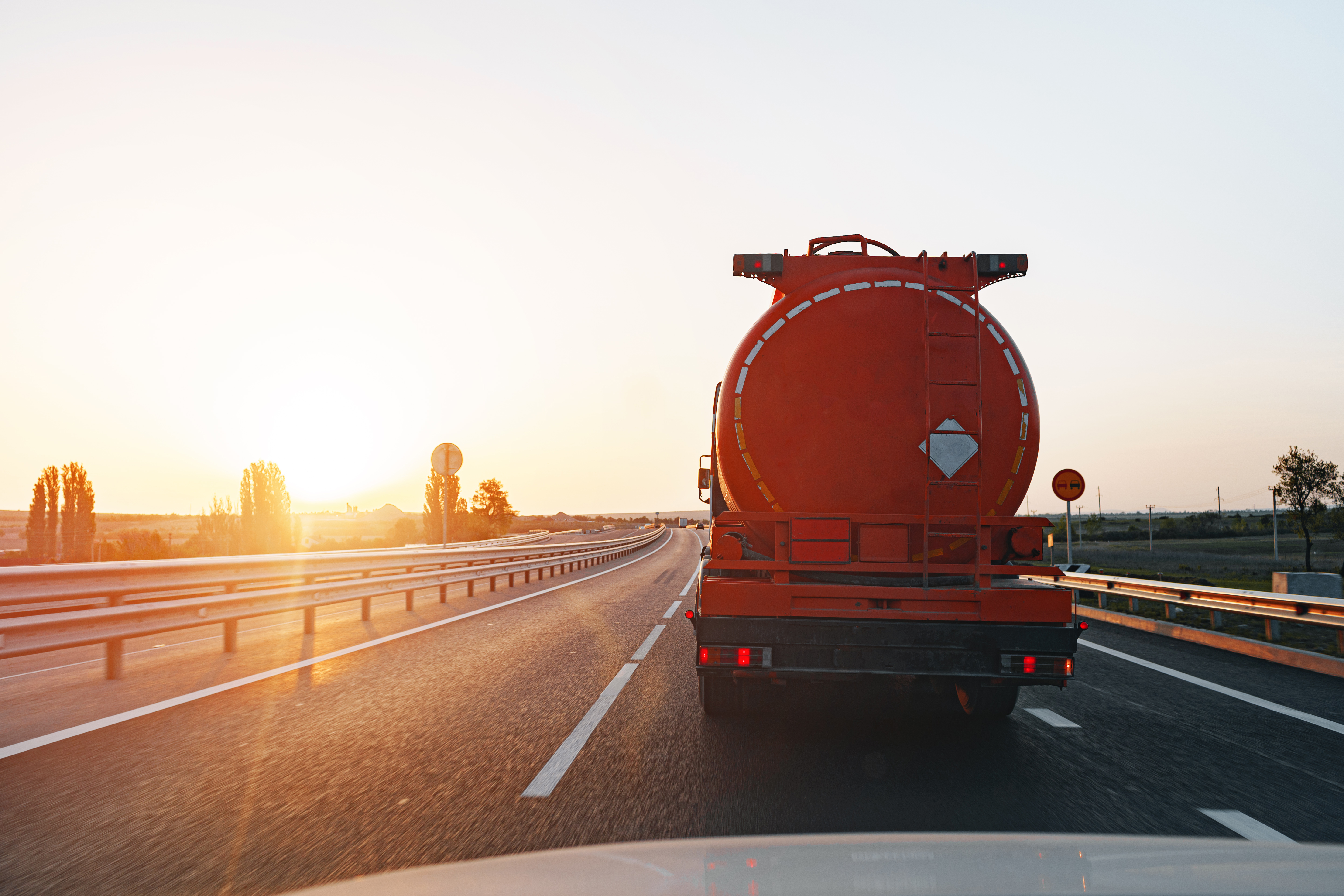 Tanker truck driving at sunrise